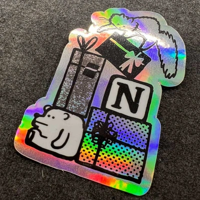 Die cut holographic sticker printed on rainbow vinyl. The holographic effect shows through the unprinted areas while the white blocks create solid colours. Printed and finished in Wicklow, Ireland.